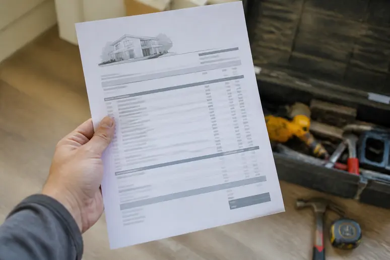 Un devis détaillé de rénovation est examiné attentivement, soulignant la nécessité d'une estimation précise des coûts pour une maison en France.