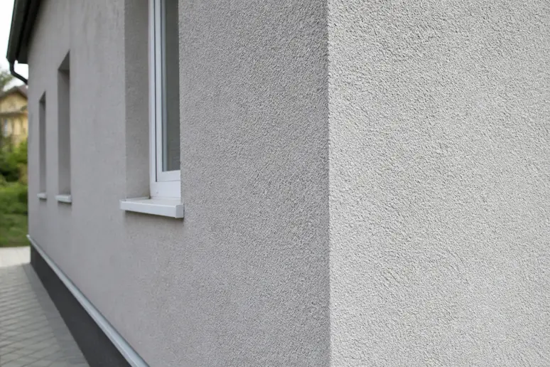 gros plan sur la texture granuleuse d un crépi extérieur fraîchement posé sur une façade