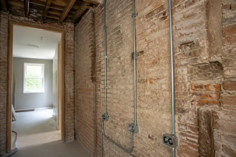 Murs anciens et réseaux techniques visibles lors de la préparation d'un chantier de rénovation