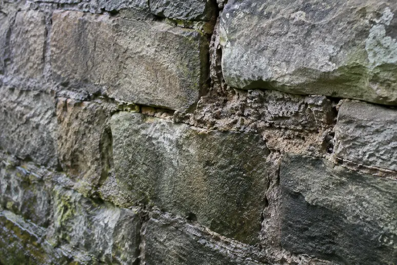 Repère visuel des joints dégradés et humides sur une maçonnerie en pierre ancienne