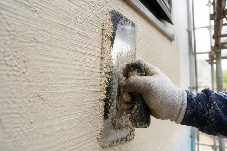 Application minutieuse d'un enduit résine pour mur exterieur sur une façade en rénovation