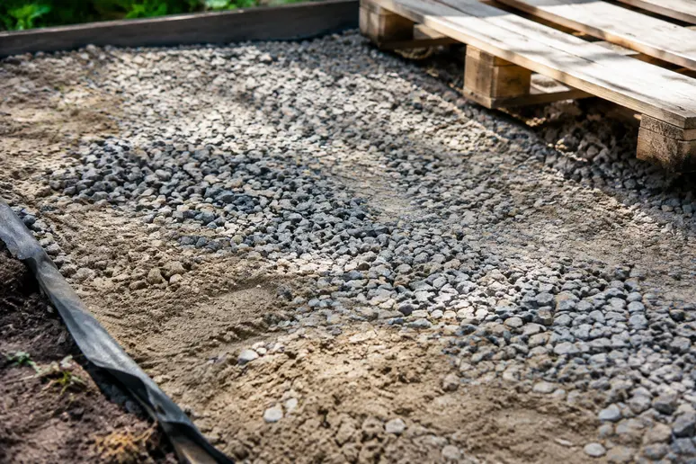 Lit de gravier et sable drainant posé sur le sol pour une terrasse en palette sur terre