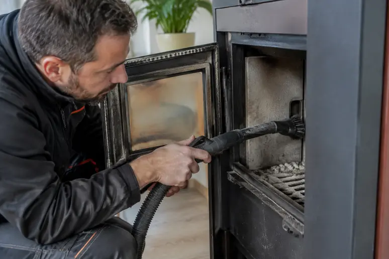 Technicien realisant l entretien annuel d un poele a granules
