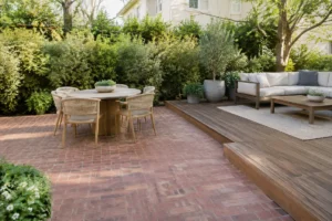 Aménagement extérieur moderne combinant terrasse brique et bois avec mobilier confortable et plantes vertes.