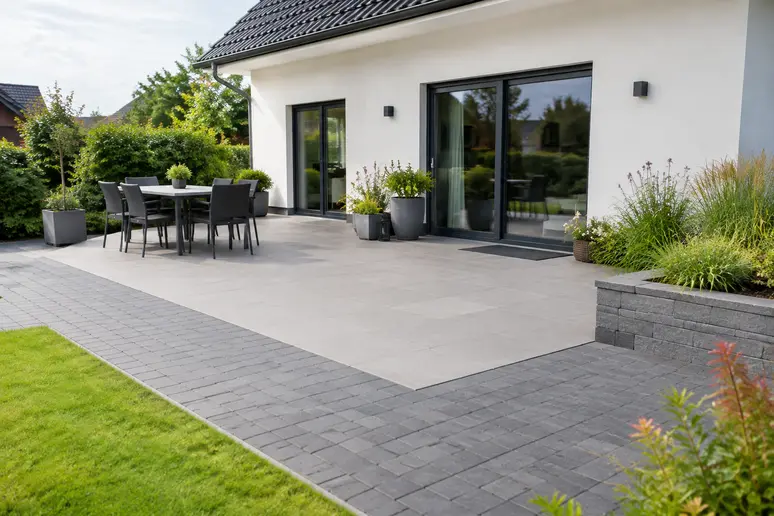 Dalles grand format et pavés posés sur une terrasse de maison pavillonnaire moderne